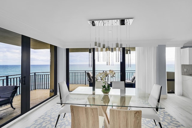 dining area with french doors, a wall of windows, and a water view