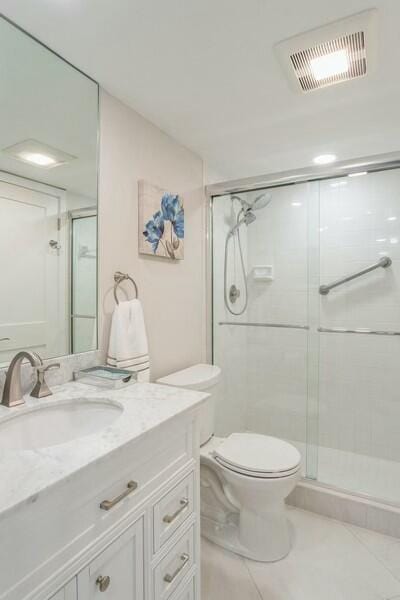 bathroom with toilet, a shower stall, visible vents, and vanity