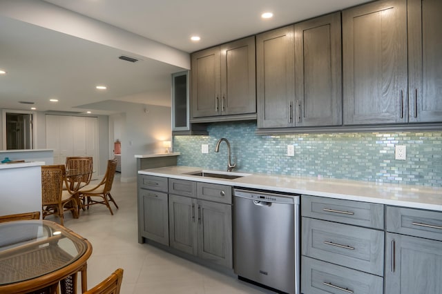 kitchen featuring gray cabinetry, light countertops, dishwasher, and a sink