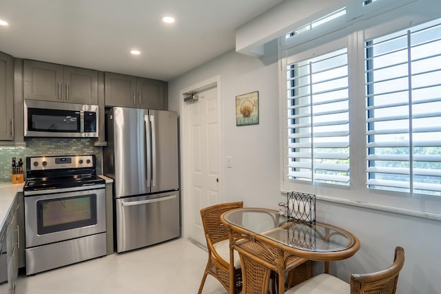 kitchen featuring decorative backsplash, appliances with stainless steel finishes, gray cabinets, light countertops, and recessed lighting