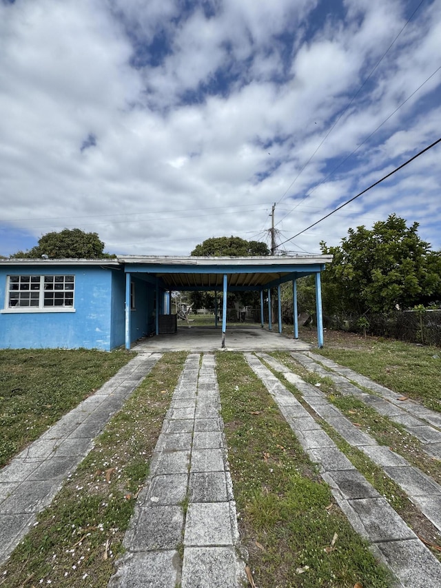 view of vehicle parking featuring an attached carport and driveway