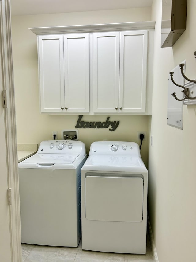 clothes washing area featuring cabinets and independent washer and dryer