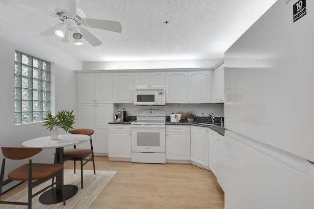 kitchen featuring sink, white appliances, white cabinets, and light hardwood / wood-style flooring