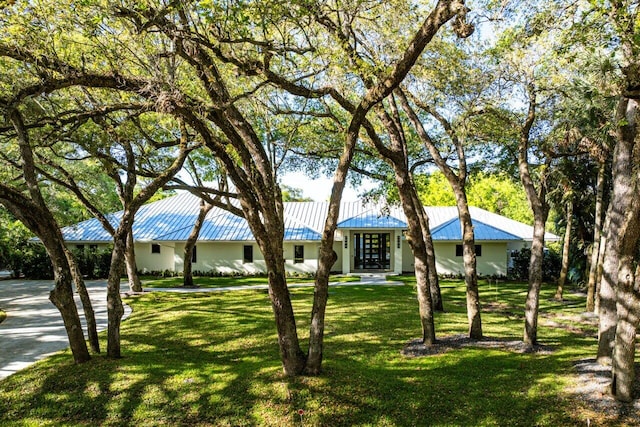 ranch-style home with a standing seam roof, french doors, metal roof, and a front yard