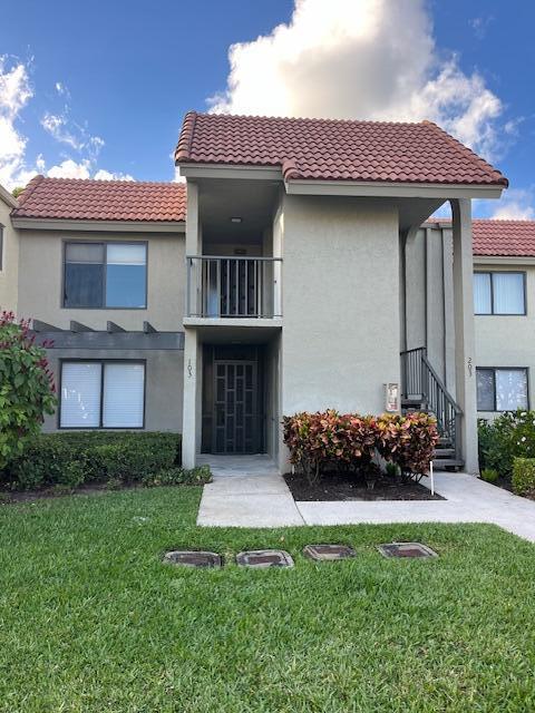 exterior space featuring a balcony and a front lawn