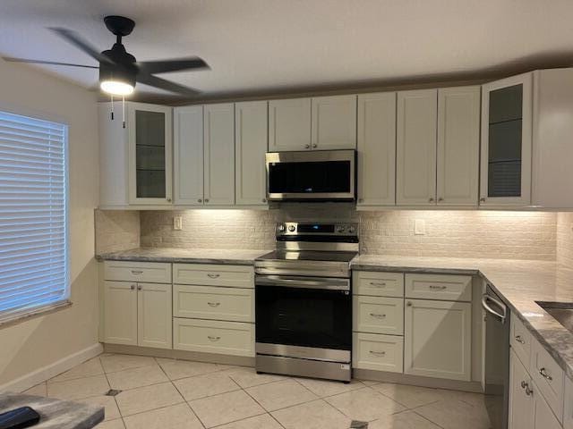 kitchen featuring white cabinets, appliances with stainless steel finishes, and decorative backsplash