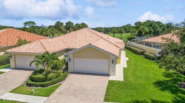 mediterranean / spanish-style house with a lanai, a front lawn, and a garage