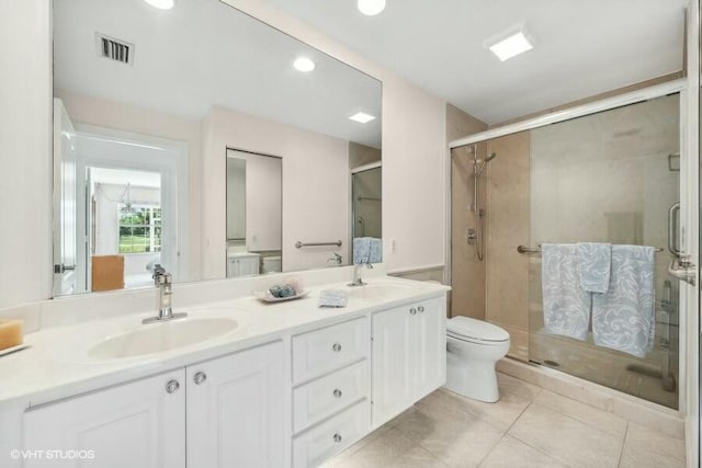 bathroom with toilet, tile patterned flooring, a shower with shower door, and vanity