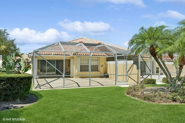 back of house featuring a patio, a lanai, and a lawn