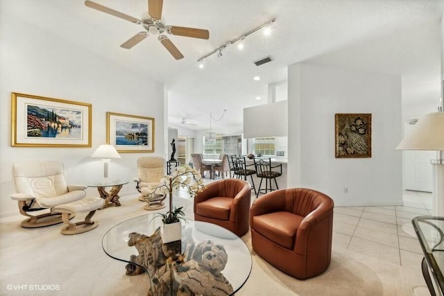 living room featuring track lighting, lofted ceiling, ceiling fan, and light tile patterned floors