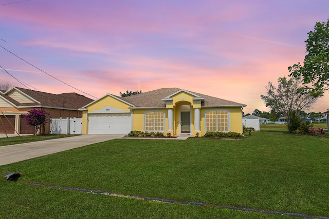 ranch-style house featuring a garage, concrete driveway, fence, a front yard, and stucco siding