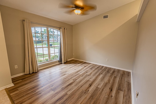 unfurnished room featuring visible vents, ceiling fan, baseboards, and wood finished floors