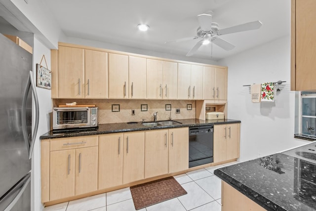 kitchen featuring a toaster, freestanding refrigerator, light brown cabinets, a sink, and dishwasher