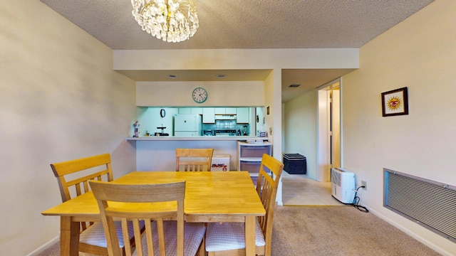 dining room with light carpet, a chandelier, and a textured ceiling