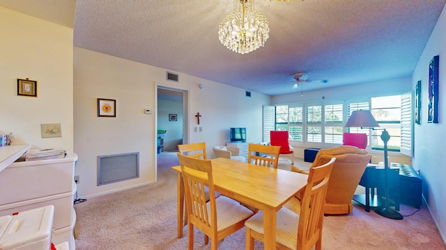 dining area with light carpet, ceiling fan with notable chandelier, and a textured ceiling