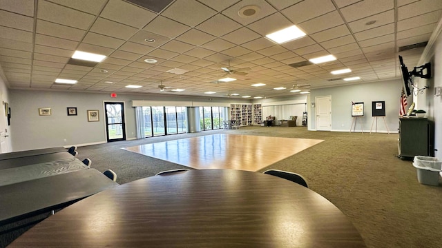 interior space featuring carpet, a paneled ceiling, and ceiling fan