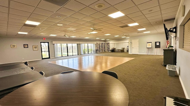 interior space featuring carpet, ceiling fan, and a paneled ceiling