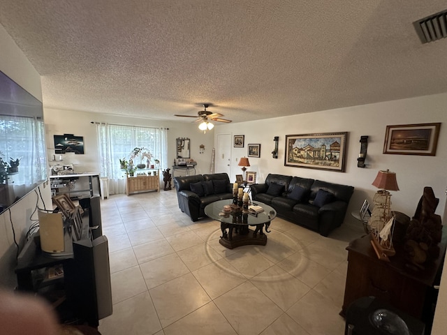 living area featuring light tile patterned floors, ceiling fan, a textured ceiling, and visible vents