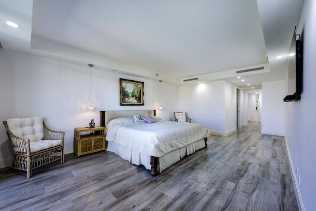 bedroom with wood finished floors, baseboards, and recessed lighting