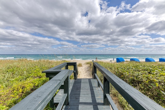 view of property's community with view of water and beach