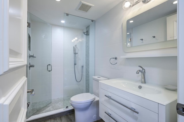 full bath featuring a stall shower, toilet, tile walls, vanity, and recessed lighting