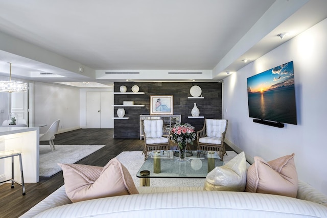 living room featuring baseboards, wood finished floors, and an accent wall