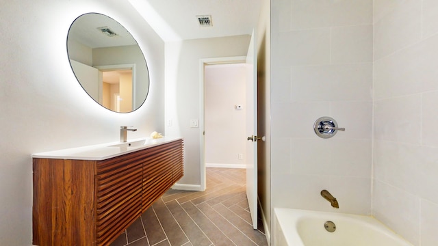 bathroom featuring hardwood / wood-style floors, vanity, and tiled shower / bath