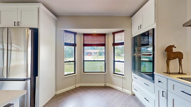 kitchen with light hardwood / wood-style flooring, stainless steel appliances, and white cabinetry