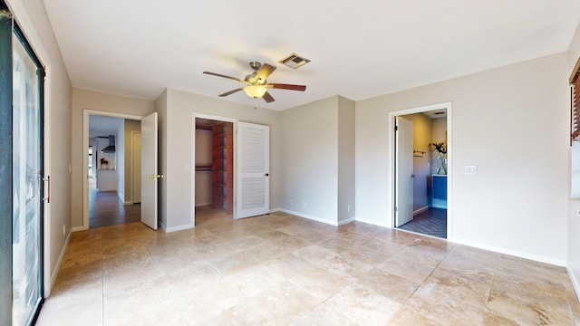 unfurnished bedroom with ensuite bathroom, a closet, ceiling fan, and a spacious closet