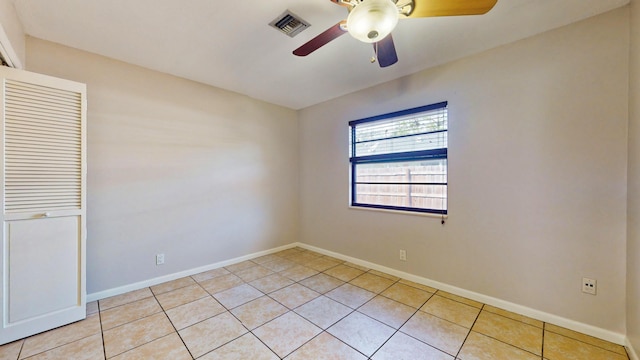 tiled empty room with ceiling fan