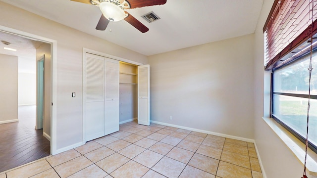 unfurnished bedroom with a closet, light tile patterned flooring, and ceiling fan