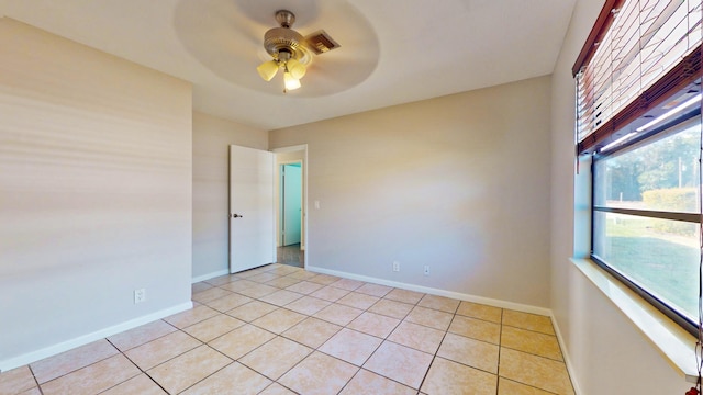 tiled spare room with ceiling fan