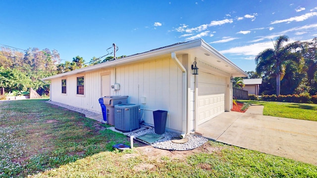 view of property exterior featuring a garage, a lawn, and central air condition unit