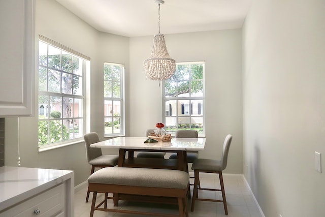 dining room with light tile patterned flooring, a notable chandelier, and baseboards
