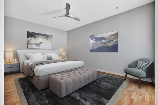 bedroom with ceiling fan, wood finished floors, and baseboards