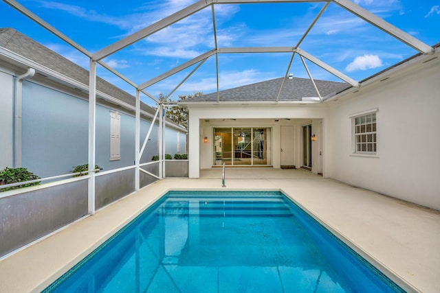 pool with a patio area and glass enclosure