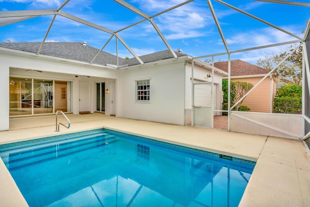 outdoor pool featuring glass enclosure and a patio