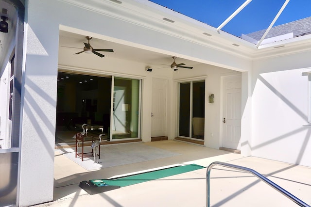 rear view of property featuring a patio, a ceiling fan, and glass enclosure