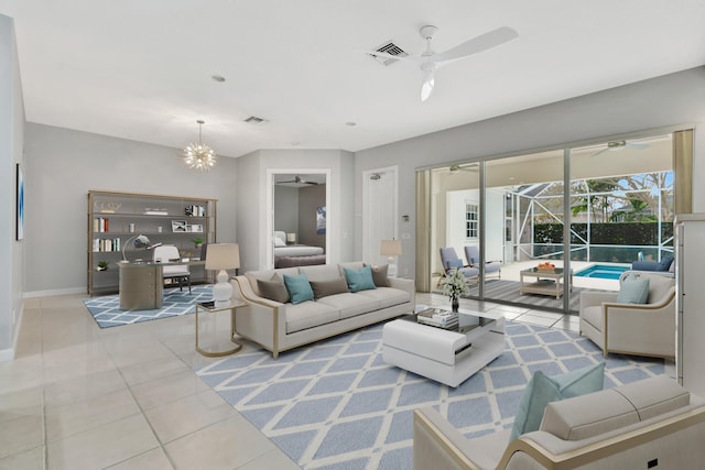 living area with a sunroom, light tile patterned flooring, visible vents, and ceiling fan with notable chandelier