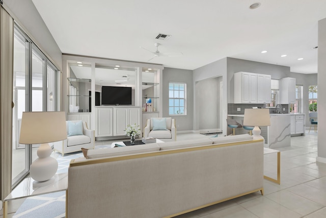 living area featuring visible vents, a ceiling fan, light tile patterned flooring, built in shelves, and recessed lighting