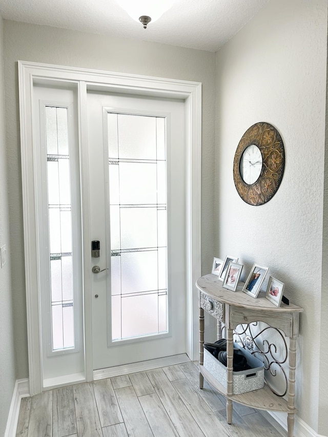 doorway to outside featuring light wood-style floors and baseboards