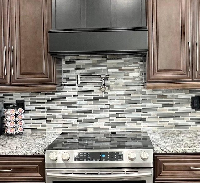 kitchen featuring dark brown cabinets, tasteful backsplash, and stainless steel range with electric stovetop