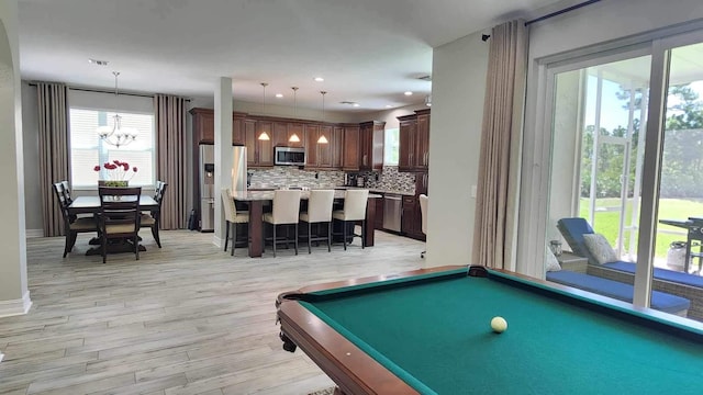 game room with a chandelier, light wood-type flooring, and recessed lighting