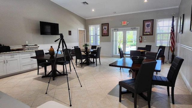 dining room with french doors, a wainscoted wall, light tile patterned floors, visible vents, and ornamental molding