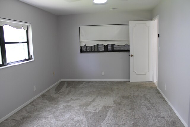 interior space featuring baseboards and light colored carpet