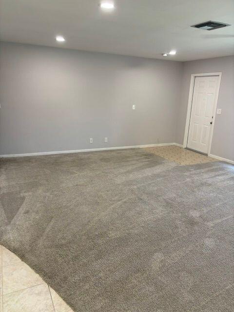 unfurnished room with carpet, visible vents, baseboards, and recessed lighting