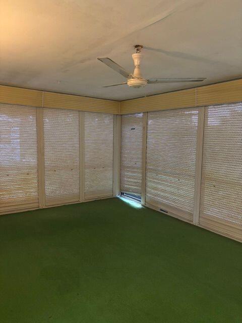 unfurnished sunroom with a ceiling fan