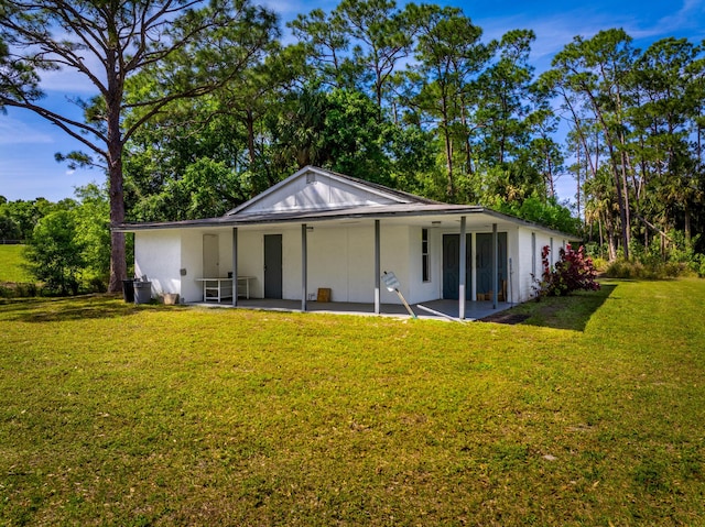 rear view of house with a yard and a patio area