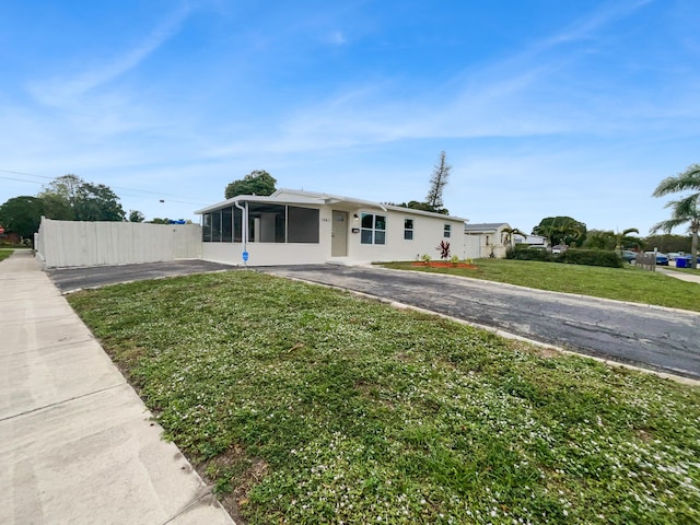 view of front of home featuring a sunroom and a front lawn