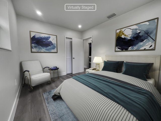 bedroom with dark wood-type flooring and a closet